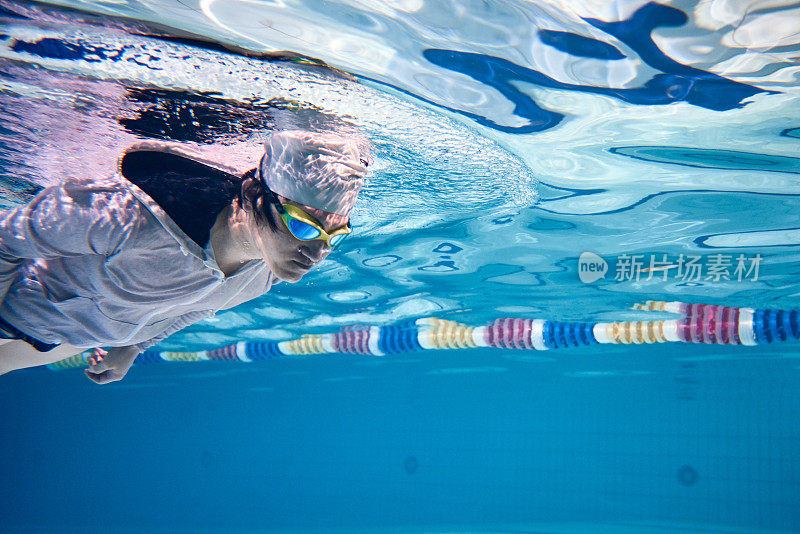 Male swimmer swimming underwater in a pool